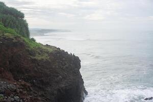 view of the cliffs on the beach with sea and clear sky photo