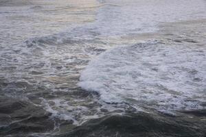Rolling Waves with White Foam Creating Intricate Patterns on the Sea Surface photo