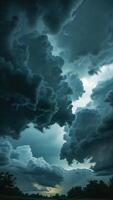 a dark sky with clouds and trees in the background photo