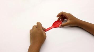 a child's hands are holding two red plastic spoons-10 photo