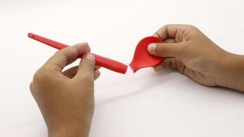 a child's hands are holding two red plastic spoons photo