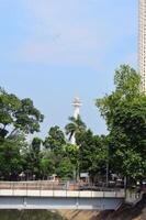 14 April 2024, View of Jakarta National Monument from afar and covered in trees photo