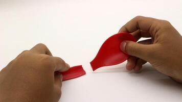 a child's hands are holding two red plastic spoons-7 photo