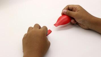 a child's hands are holding two red plastic spoons-11 photo
