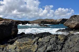 Waves Crashing on to the Black Lava Rock Cove photo