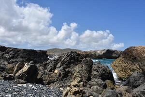 Waves Splashing Over Scattered Rocks in Aruba photo
