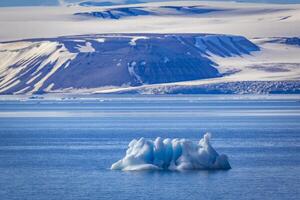 small iceberg at Cruising at perfect weather in the Arctic with an expedition between Nordaustlandet and Spitsbergen on Svalbard, Norway photo