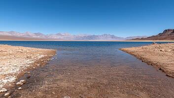 Tranquil lake in a desert landscape with mountains in the background photo