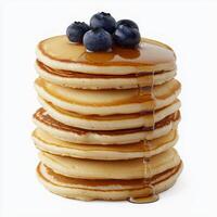 A tall stack of pancakes with blueberries and syrup on top photo