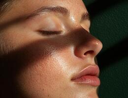 Close up of a womans face with sun kissed skin and closed eyes photo