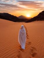 Person in white robe walking on sand dunes at sunset photo
