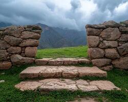Stone steps leading to a grassy field with mountains in the background photo