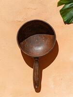 Rustic wooden cooking spoon on a peach background photo