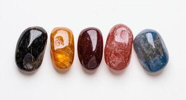 Five tumbled gemstones in a row on a white background photo