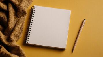 Blank notepad and pen on yellow background photo