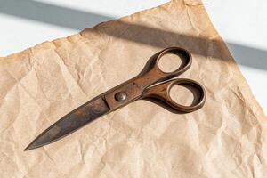 Antique rusty scissors on crumpled brown paper photo