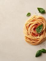 spaghetti with tomato sauce and basil leaves on a beige background top view photo