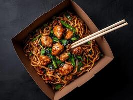Delicious chicken and noodles takeout in a brown cardboard box photo