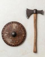 Ancient battle axe and shield on a light background photo
