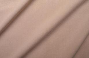 Brown cotton fabric texture, fabric wrinkles, waves and shadows. photo