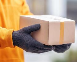 friendly delivery person in warm orange sweater is carefully placing package in their hands, showcasing moment of service and care photo