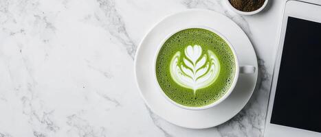 beautifully crafted matcha latte sits on marble table beside tablet, creating serene atmosphere photo