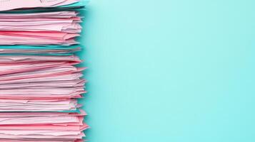 Meticulously arranged pile of colorful tax forms on turquoise background, showcasing organization and paperwork photo
