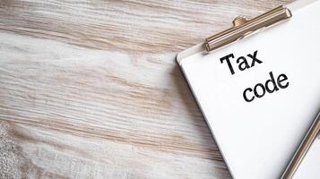 Tax code document on clipboard resting on wooden surface, symbolizing financial planning and organization photo