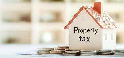 Property tax model house with coins on table, symbolizing finance photo