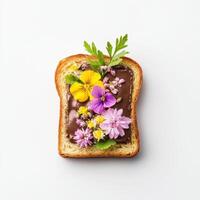 Toasted bread topped with chocolate ganache and colorful edible flowers photo