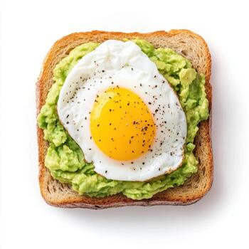 Toasted bread topped with mashed avocado and fried egg, garnished with pepper photo
