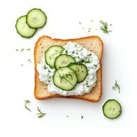 Toasted bread topped with tzatziki and fresh cucumber slices, garnished with herbs photo