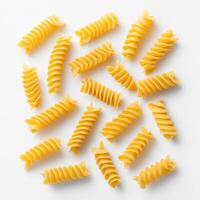 Uncooked fusilli pasta spirals scattered on white background, showcasing their unique shape and texture photo