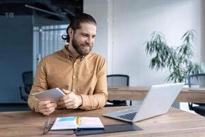 Confident professional working in a contemporary office space, utilizing technology for productivity. The image conveys effective work practices and modern approach to tasks in business environment. photo