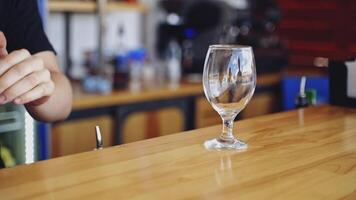 Transparent glass with ice cubes. Bartender is putting crystal ice cubes in a glass before preparing an alcoholic cocktail to customers on the bar table. video