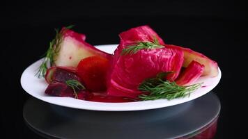 pickled cabbage with beets and carrots, in a plate, isolated on black background video
