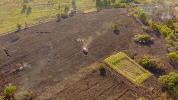 Fire truck moving on burnt field. Brown field after the fire in summer. Environment in danger. Natural environment in smoke after the fire accident. Aerial view. video