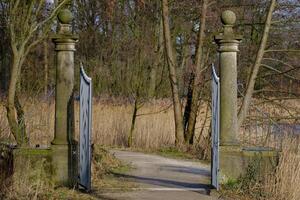 A gate that is open to a path photo