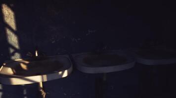 Rustic bathrooms with worn sinks and shadows in a dimly lit space video