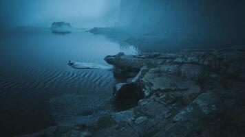 Foggy waterscape at dawn with rocky shoreline and calm reflections video
