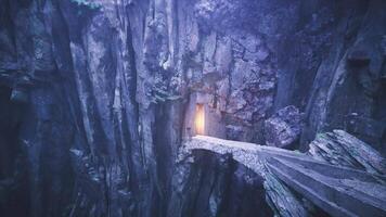 Mysterious cave entrance illuminated by soft light at rocky cliff video