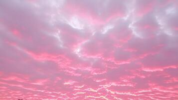 Pink and gray clouds fill the sky at sunset. photo