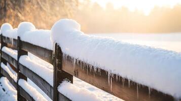 Snow-covered wooden fence in winter sunrise. photo