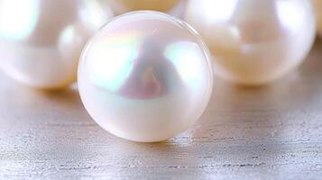 Close-up of lustrous, creamy white pearls on a light wooden surface. photo