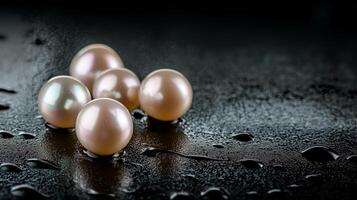 Five lustrous pearls on a dark, wet surface. photo