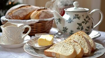 A table with a plate of bread, butter and a cup of tea photo