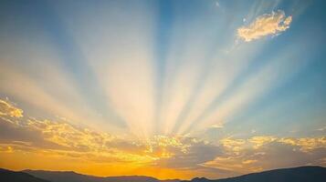 Vibrant sunset with sun rays bursting through clouds over mountains. photo