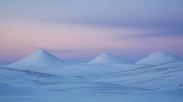 Serene winter landscape with three snow-covered peaks at dusk. photo