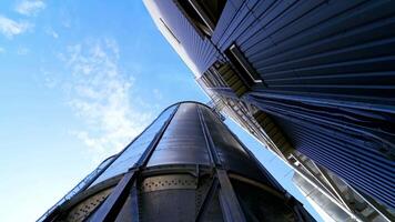 Industrial grain storage tanks. Large silver elevators for processing grain. Modern silos. Close-up. View from below. video