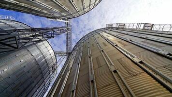 Aluminum containers for storing grains. Exterior of large metal elevators. Close-up. View from below. Camera motion around. video
